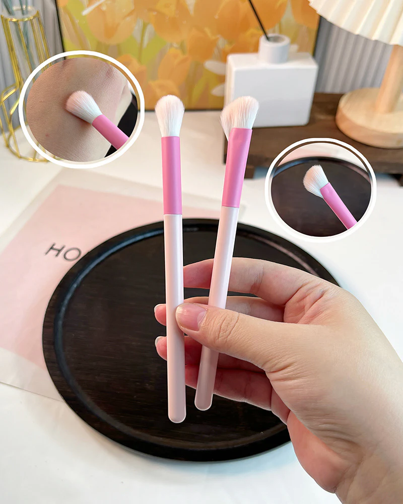 Two eye brushes shown by hand